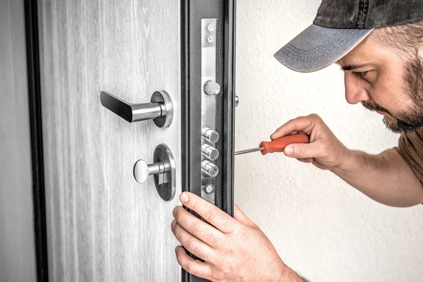 Serrurier réglant une serrure multipoints sur une porte à Goussainville